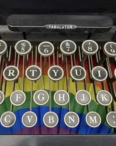 Round typewriter keys with black letters above a rainbow-colored fan