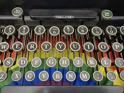 Round typewriter keys with black letters above a rainbow-colored fan