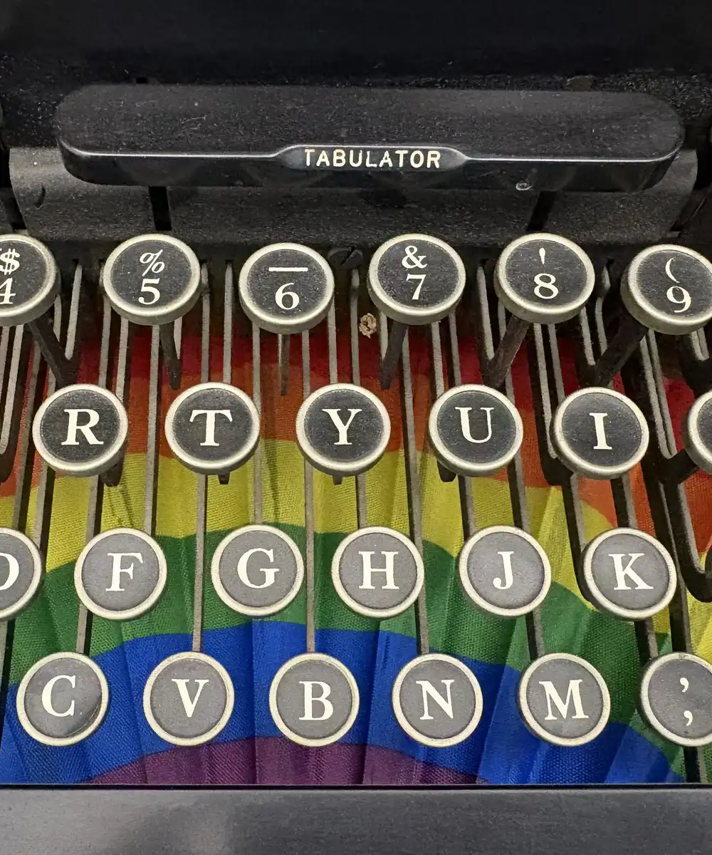 Round typewriter keys with black letters above a rainbow-colored fan